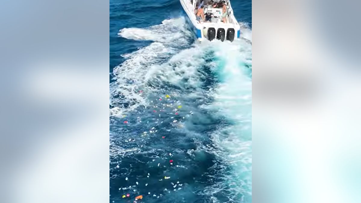 Une traînée de déchets se trouve derrière le bateau après que les fêtards de Boca Bash ont jeté des poubelles dans l'Atlantique.