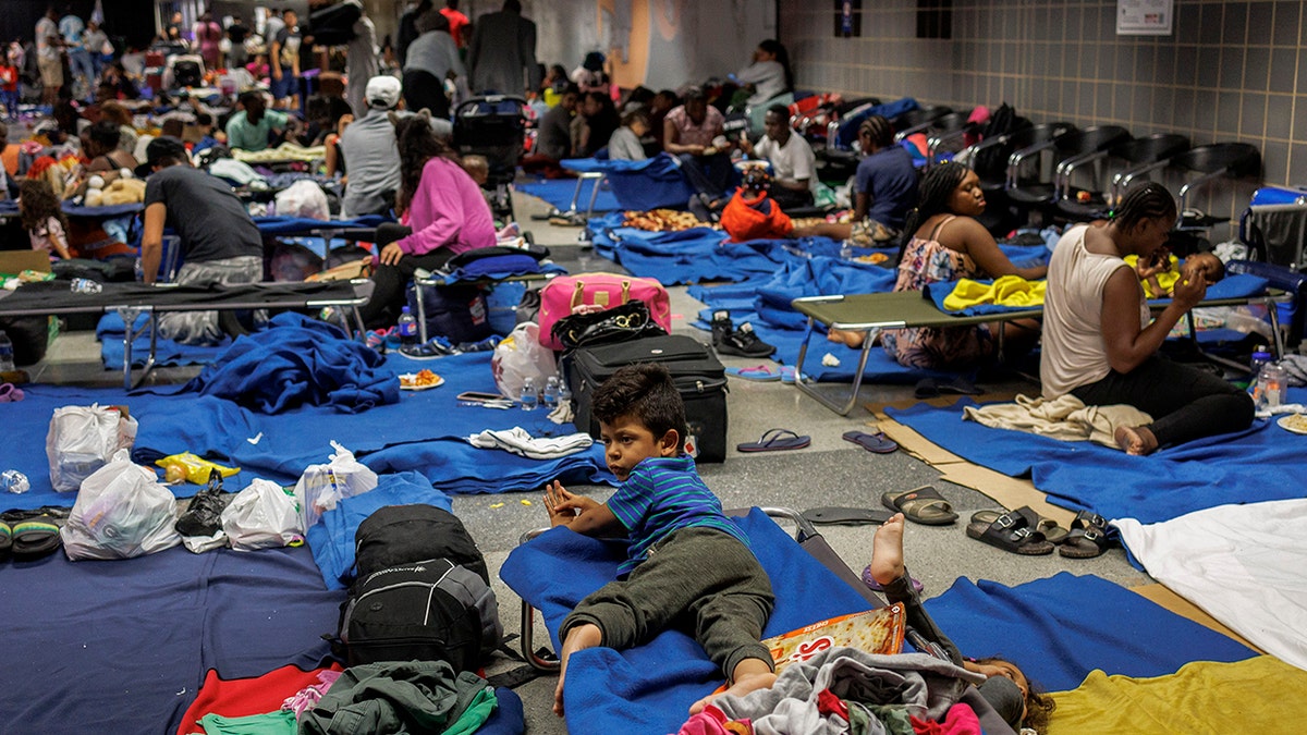 Des migrants à terre et sur des lits de camp dans un abri de fortune à l'aéroport international O'Hare de Chicago